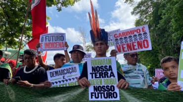 Indígenas marchando sostienen pancartas en las que se lee en portugués: Robaron nuestra tierra, quieren robar nuestro futuro” y “El futuro es indígena”