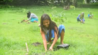 Niña planta árbol en Filipinas