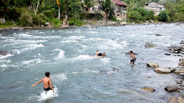 Niños bañándose y jugando en el río