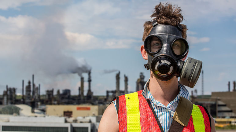 Un hombre protesta con una máscara de gas contra la extracción de arenas bituminosas en Canadá