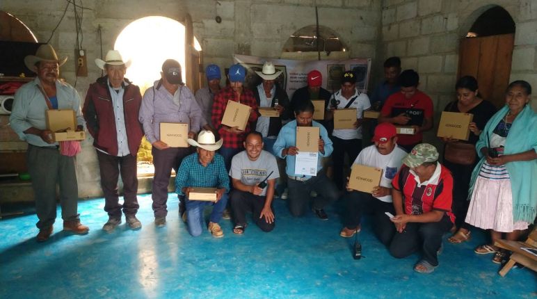 Habitantes de la comunidad de Chilon reciben aparatos de radio para mejorar la comunicación y la seguridad Un grupo de personas con cajas en la mano, sobre las que se lee la marca Kenwood, de aparatos de radiocomunicación
