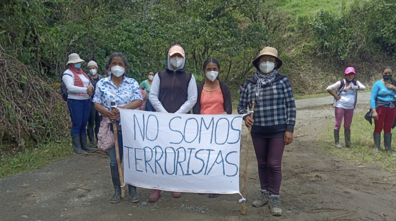 Mujeres acusadas de terrorismo por defender la vida y la naturaleza frente a la minería protestan con un cartel "No somos terroristas"