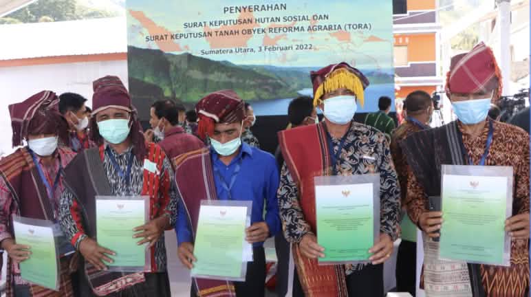 El Presidente Joko Widodo entregó personalmente los certificados de reconocimiento del bosque ancestral 5 hombres con vestimenta Batak muestran certificados de su bosque ancestral