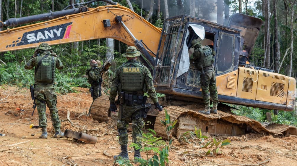 Intervención de la agencia medioambiental IBAMA. Un grupo de hombres con trajes militares intervienen una draga amarilla en la selva tropical