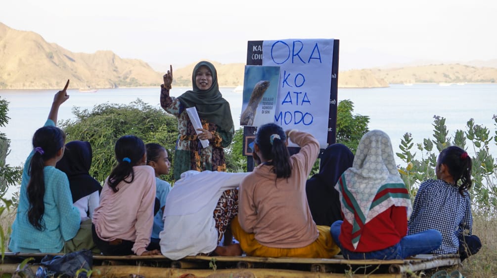 Niñas aprenden con fotografías acerca del dragón de Komodo