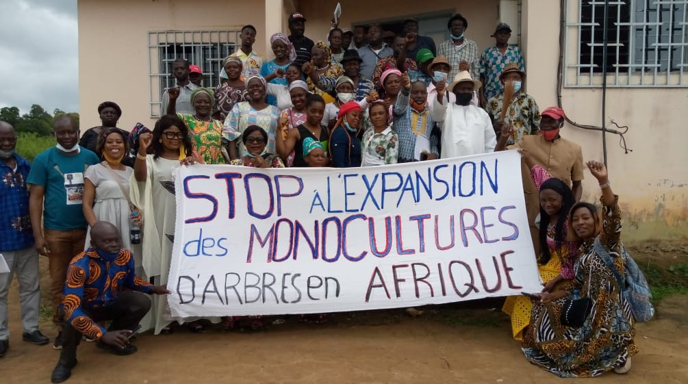Grupo de personas afectadas protestan con una pancarta en la que se lee (en francés): “Detengan la expansión de los monocultivos de árboles en África”