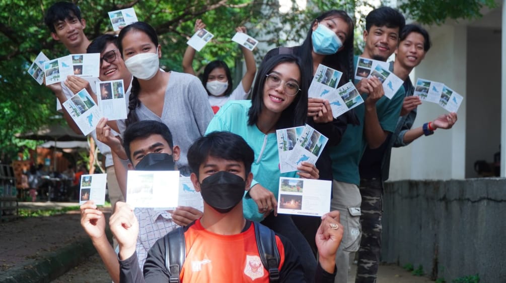 Campaña ambiental del grupo de jóvenes de Mother Nature Camboya, que sostienen fotos de la isla de Koh Kong que quieren proteger