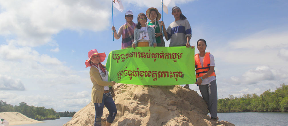 “Detengan la extracción de arena en la provincia Koh Kong”, exige la organización Mother Nature en Camboya Ecologistas sobre un cúmulo de arena sostienen una pancarta