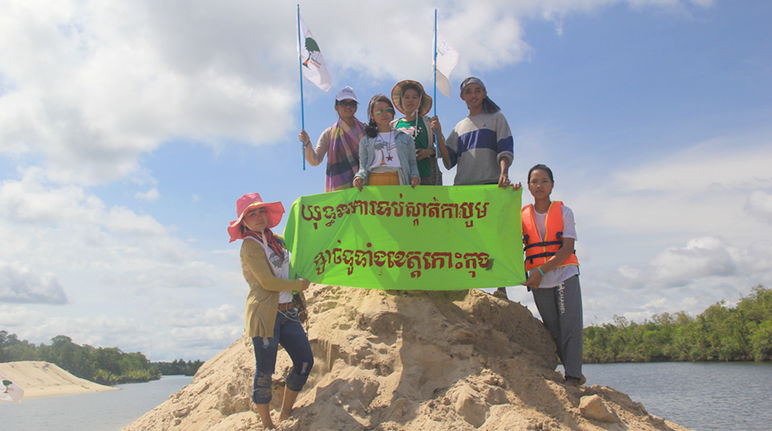“Detengan la extracción de arena en la provincia Koh Kong”, exige la organización Mother Nature en Camboya Ecologistas sobre un cúmulo de arena sostienen una pancarta